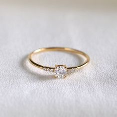 a diamond ring sitting on top of a white cloth