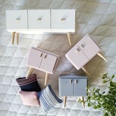 four miniature furniture on a bed next to a potted plant