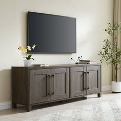 a flat screen tv mounted to the side of a wooden cabinet in a living room