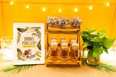 an arrangement of pineapples and honey in jars are displayed on a table next to a framed poster