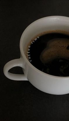 a white cup filled with liquid on top of a table