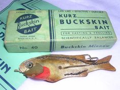 an old fishing lure next to a box of kurbz buckkin'bait