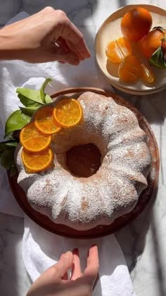 someone is placing orange slices on top of the cake