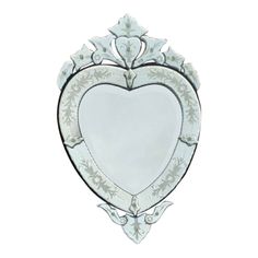 a white heart shaped mirror hanging on the side of a wall in front of a white background