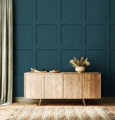 a wooden cabinet sitting on top of a hard wood floor next to a blue wall