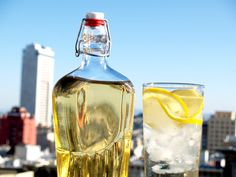 a bottle of lemonade next to a glass filled with ice and water on top of a roof