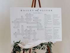 a crossword puzzle board on a easel with greenery in front of it