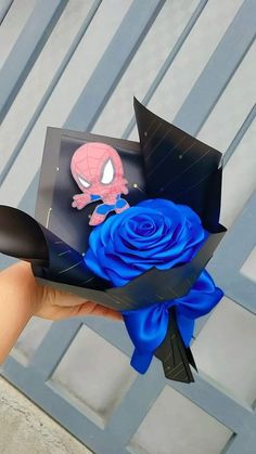 someone is holding a paper flower with a spiderman on it