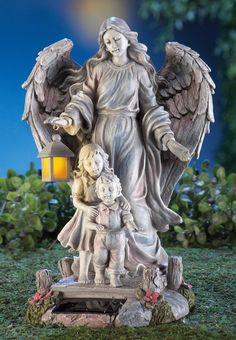 an angel statue with two children in it's arms and a light shining on the ground