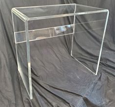 a clear acrylic desk on a black clothed background with a gray backdrop