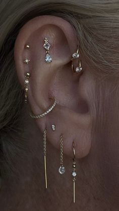 a woman's ear with three different types of piercings