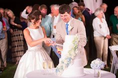 a newly married couple cutting their wedding cake