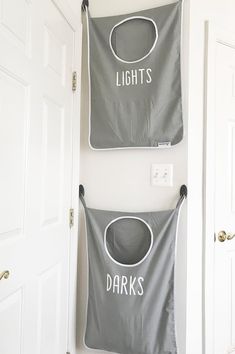 two laundry hampers hanging on the wall with lights and darks written on them