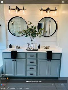 a bathroom with two sinks, mirrors and lights on the wall above them is shown