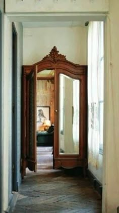 an open doorway leading to a bedroom with a mirror on the wall