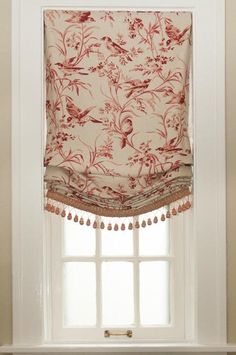 a window with a red and white floral curtain on it's valance in front of a window sill