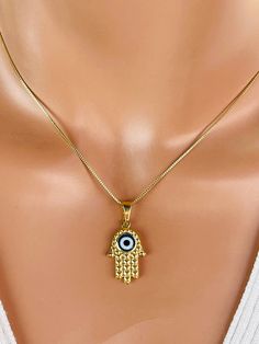 This is a beautiful Hamsa necklace with evil eye center.  Hamsa Pendant is 14k gold filled, measures 24x14mm and has a blue evil eye center.  Pendant is double sided. This pendant now comes on a 14k gold filled box chain with spring clasp in back.  This necklace comes on a  16" or 18" length.  Comes nicely boxed, the perfect. Why you should choose Gold Filled Jewelry... Gold filled jewelry is an actual layer of gold pressure bonded to another metal. Gold filled is not to be confused with gold pl Liquid Jewelry, Evil Eye Art, Hamsa Evil Eye, Custom Necklaces, Eye Center, Girls Jewelry Box, Hamsa Pendant, Necklaces Women, Hamsa Necklace