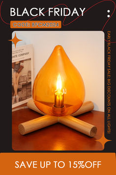 a candle is sitting on top of a table with two wooden sticks and a book