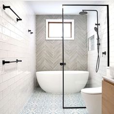 a bathroom with a tub, toilet and shower head in the middle of the room