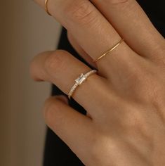 a woman's hand with a gold ring and diamond band on her left wrist