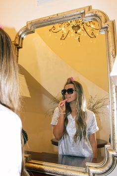 a woman brushing her teeth in front of a mirror