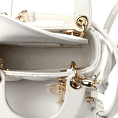 This is an authentic CHRISTIAN DIOR Lambskin Cannage Micro Lady Dior in White. This small handbag is crafted of white leather with a geometric quilted pattern in white. The handbag features rolled leather handles, an optional chain shoulder strap, and gold hardware including handle rings, clasps, decorative eyelets, and a hanging “Dior" letters charm. The top is secured by an interior flap and opens to a light beige suede interior with a zipper pocket. Micro Lady Dior, Quilted Pattern, Small Handbag, Letter Charms, Leather Handles, Small Handbags, Lady Dior Bag, Lady Dior, Bag Straps