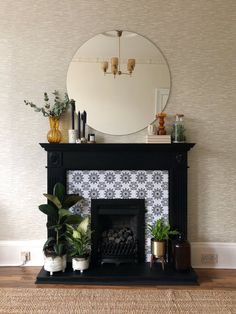 a fireplace with potted plants and a mirror on top of the mantel in front of it