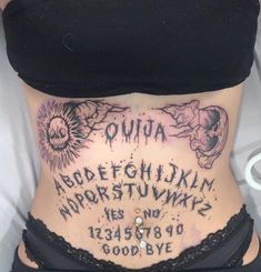 a woman's stomach with tattoos on it and the words oujua written in cursive writing