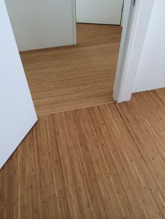 an empty room with wooden floors and white walls is seen through two open doorways