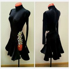 a black dress with flowers on the back and an orange purse in front, sitting on a mannequin