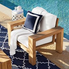 a wooden chair sitting next to a swimming pool