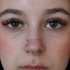 a woman with piercings on her nose and nose ring around the middle of her nose