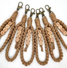 six keychains with words on them are lined up in the shape of letters