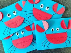 four blue paper cards with red faces and eyes on them, one is made to look like a crab