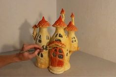 a person is decorating a house made out of clay