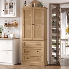 a tall wooden cabinet in a kitchen next to a white counter top and cupboards