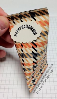 someone is holding an origami triangle with the word happy halloween on it,