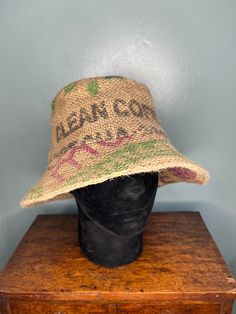 *Handmade individual bucket/sun hat crafted from a coffee bean sack with a lining of pre-loved twill cotton. *Size: Medium - Circumference 24" *This unique hat shows printed/stencilled words Café de Nica and clean coffee on the main body of the hat. The outer brim has general stencilled coloured letters & images relating to the coffee manufacturer, the top and inner brim are plain. *Care instructions: machine washable 30 degrees - cool wash - line dry. Iron using a steam setting. The hat is indi Coffee Bean Sacks, Clean Coffee, Unique Hats, Coffee Bean, Bucket Hats, Safety Pin, The Coffee, Sun Hat, Hat Crafts