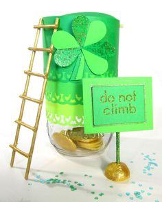 there is a green glass with gold coins in it and a sign that says do not climb