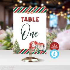 a table sign with an image of two sweaters on it and the words, table one