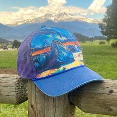 *Please note some of the images show the hat with the larger woven logo. The logo on this hat is the small Sipsey Wilder rubber logo. This hat is a collaboration with Chilean water colorist Vicki Speck. Her gorgeous water color paintings of mountains and nature will be seen on more products to come! Check her out on instagram @vickispeckart Made from 100% recycled cotton and purple polyester mesh, this completely rad trucker is printed with an original water color painting by Vicki Speck. Royal Summer Baseball Cap With Graphic Print And Curved Brim, Summer Cap With Graphic Print, Casual Adjustable Hat With Graphic Print, Summer Graphic Print Cap, Outdoor Graphic Print Trucker Hat With Curved Brim, Outdoor Trucker Hat With Graphic Print And Curved Brim, Summer Outdoor Hat With Graphic Print, Graphic Print Snapback Hats For Outdoor, Graphic Print Curved Bill Hat One Size