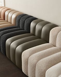 a row of couches lined up against a wall in different colors and sizes,