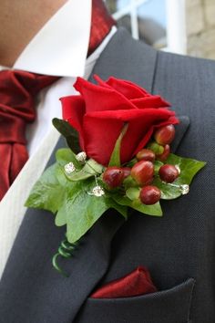 a man in a suit with a red rose on it