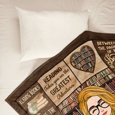 there is a blanket on the bed with some books and a woman's face