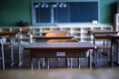 an empty classroom with desks and a chalkboard