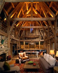 a living room filled with lots of furniture and wooden beams on top of the ceiling