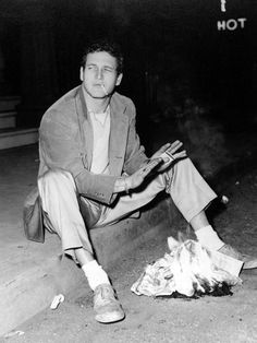 a black and white photo of a man sitting on the ground