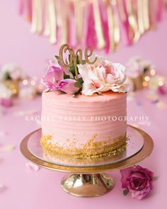 a cake with pink frosting and gold sprinkles