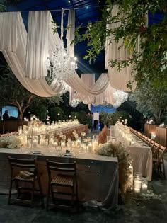 a table with candles and chandeliers hanging from it's ceiling is set up for a formal function