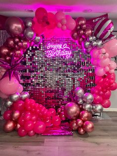 a pink and silver birthday backdrop with balloons